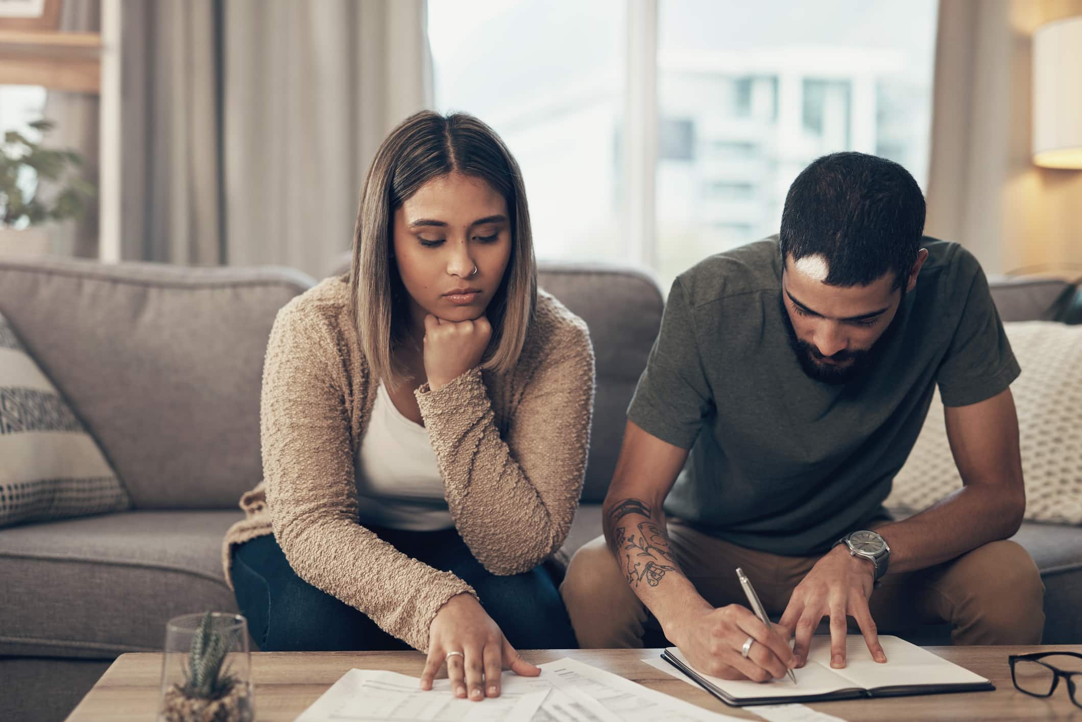 Shot of a young couple going over paperwork at home