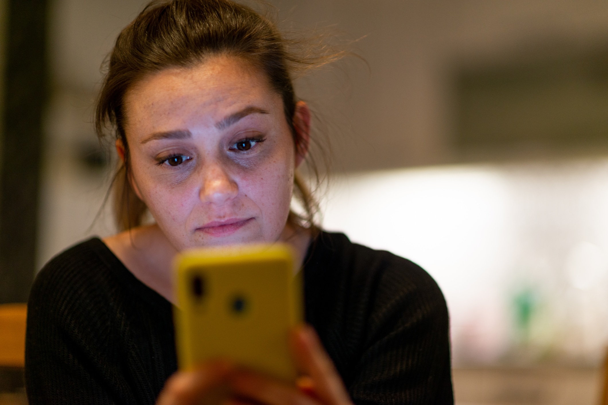 Young woman looking at smartphone confused by received sms or notification, bad news reading on cell phone feels upset, negative response concept.