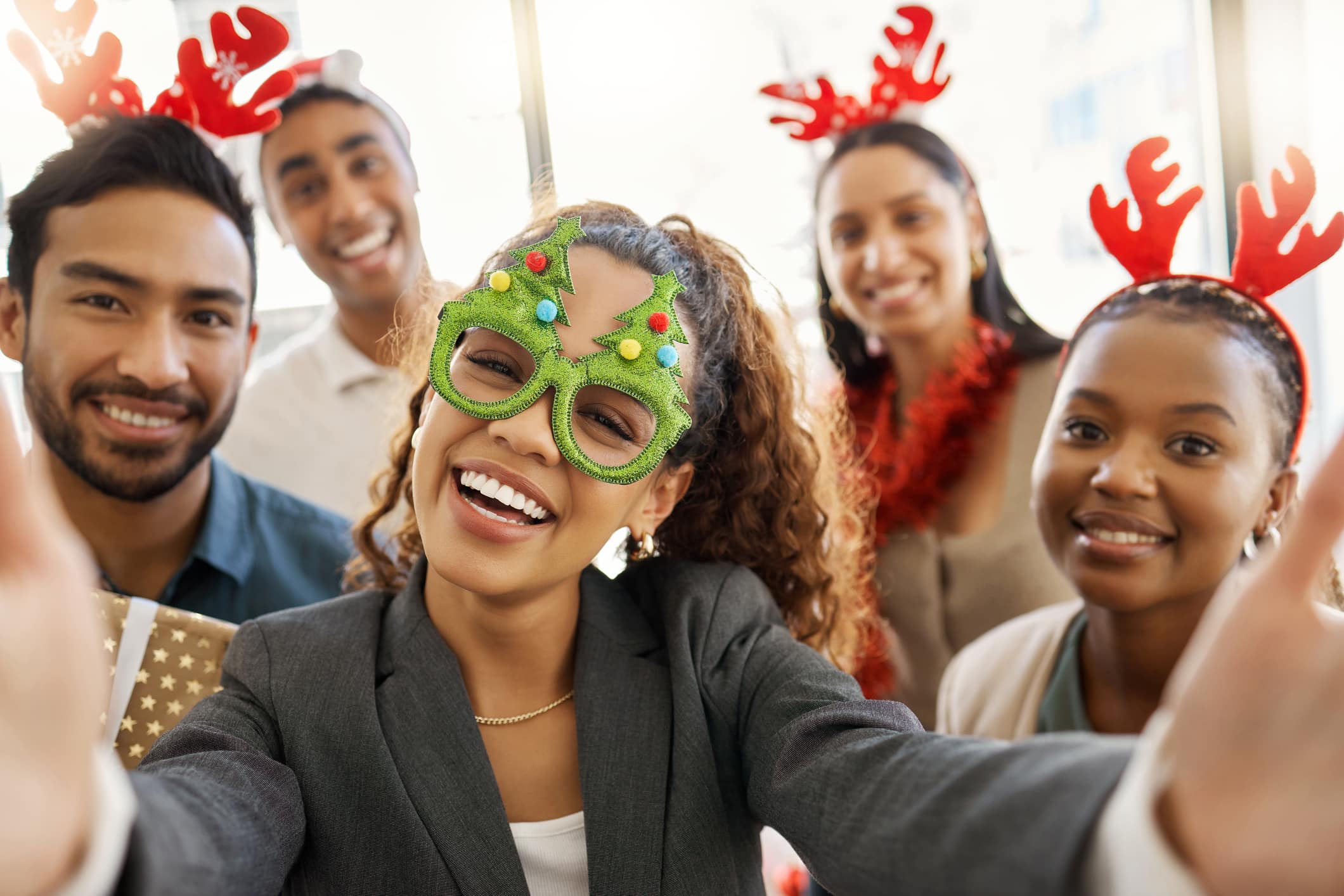 Shot of a group of businesspeople taking a selfie during a Christmas party at work