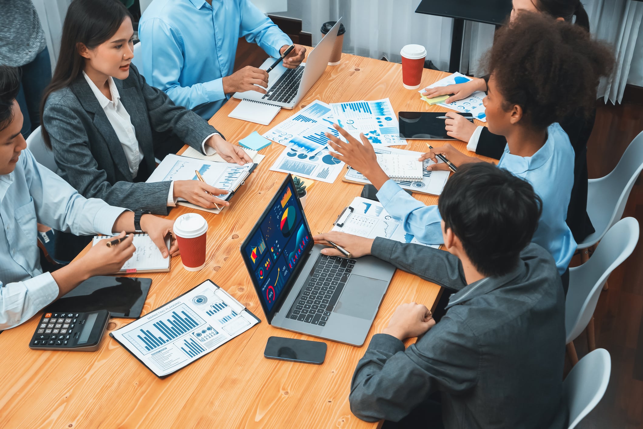 Multiracial analyst team use BI Fintech software to analyze financial data on meeting table. Financial dashboard data display on laptop screen with analyzed chart for marketing indication. Concord