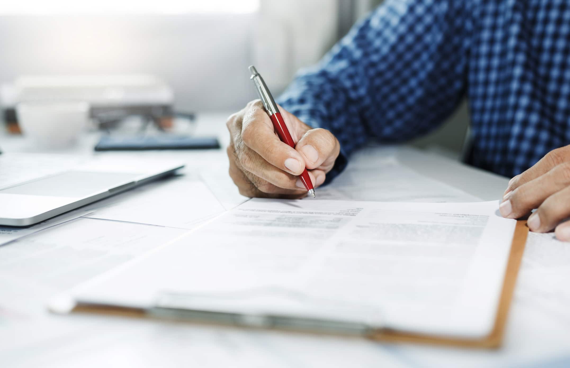Close-up view, asian businessman reviewing before sign document reports at office workplace. legal expert, professional lawyer reading and checking financial documents or insurance contract