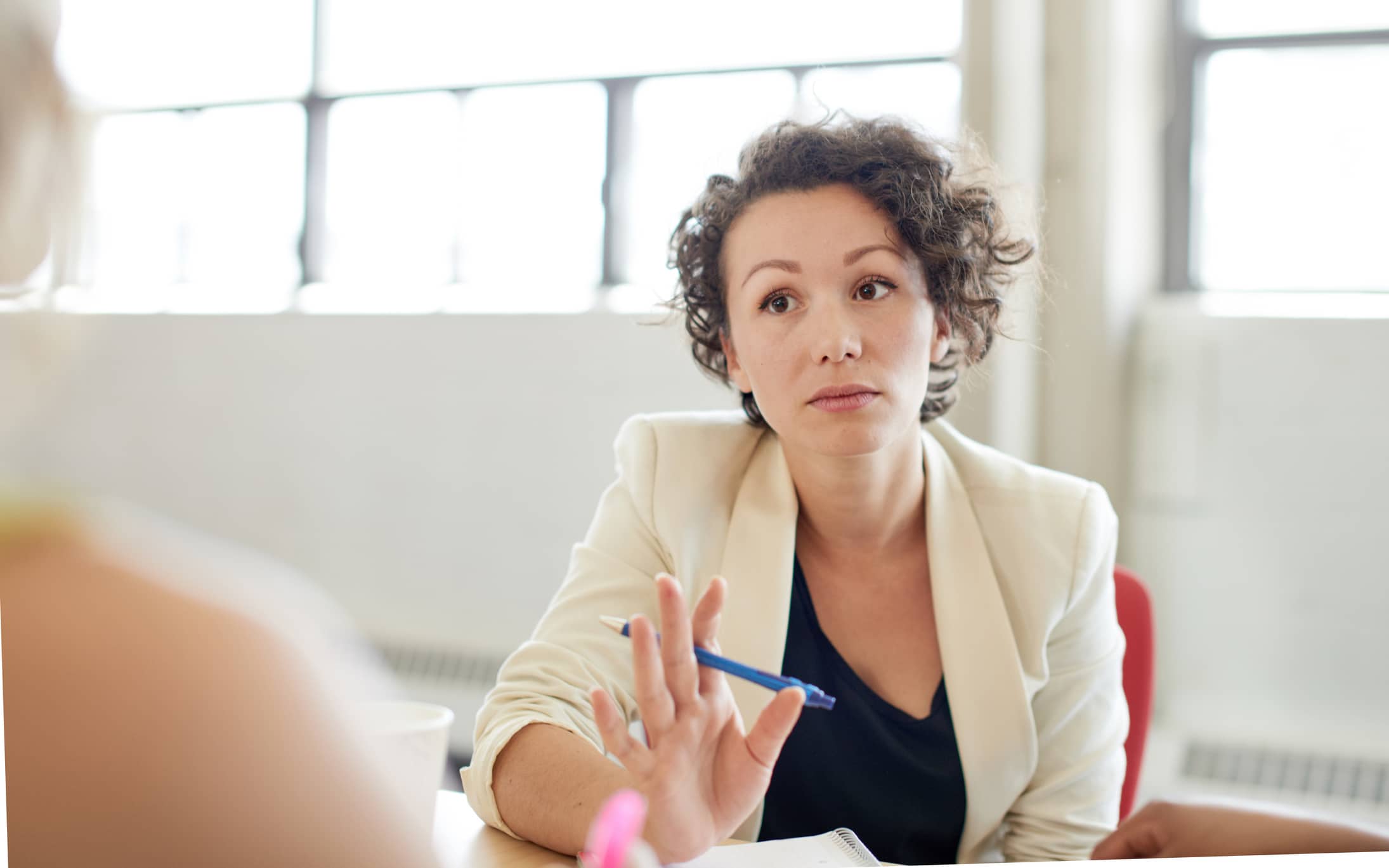 Candid picture of a female boss and business team collaborating. Filtered serie with light flares, bokeh, warm sunny tones.