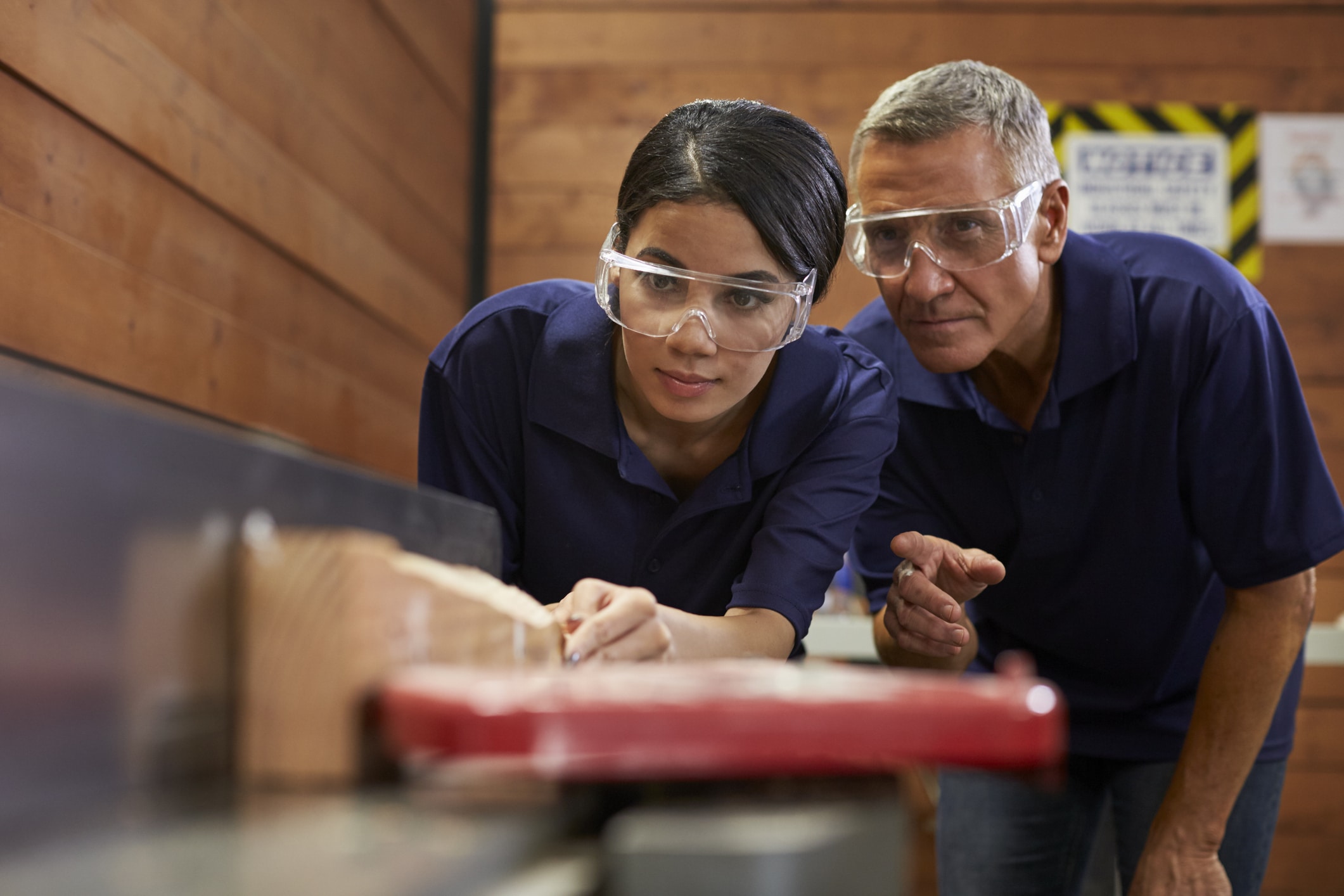young intern using machinery with middle aged man