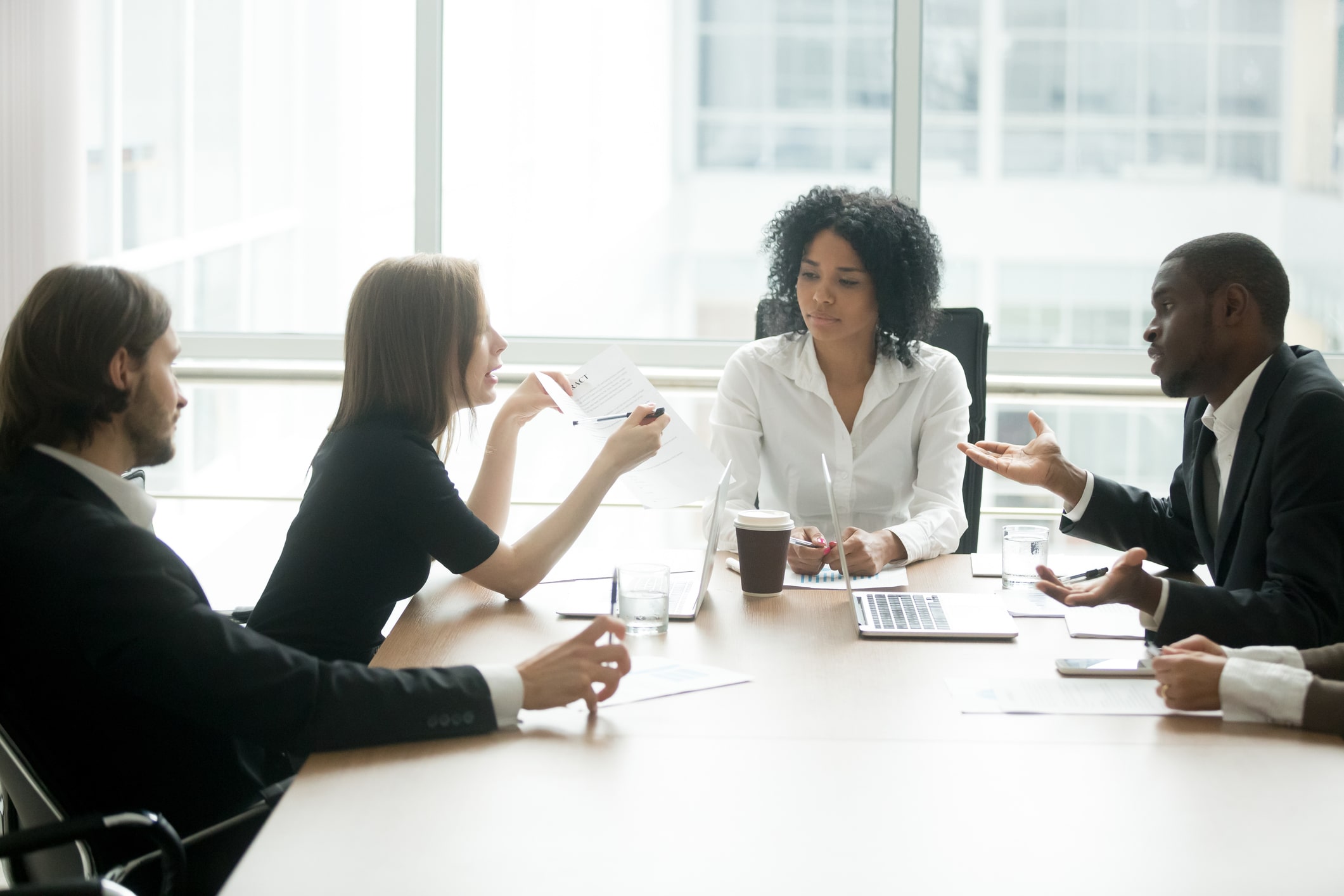 Diverse business partners arguing about bad contract at meeting
