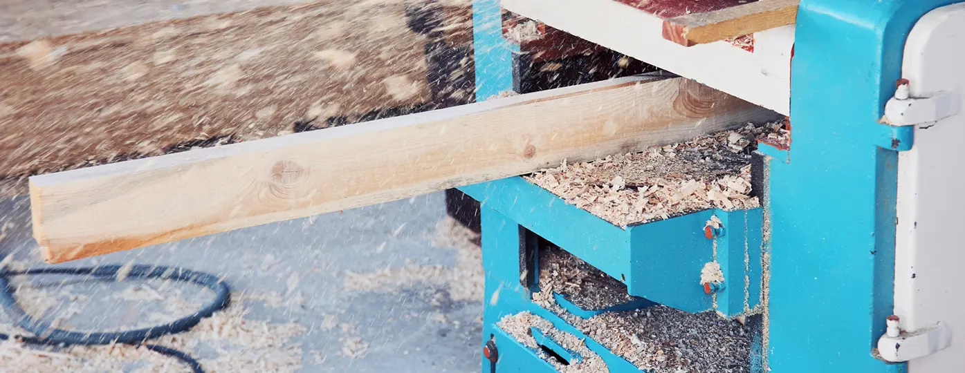 board going through wood planer