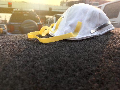 PM2.5 dust mask protection in front of car. Ready to wear when go outside to protect air pollution.