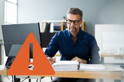 hr manager at desk analyzing paperwork, caution sign
