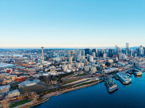 Aerial view of Seattle skyline, Space Needle, Elliott Bay waterfront and historic piers at sunset, USA.